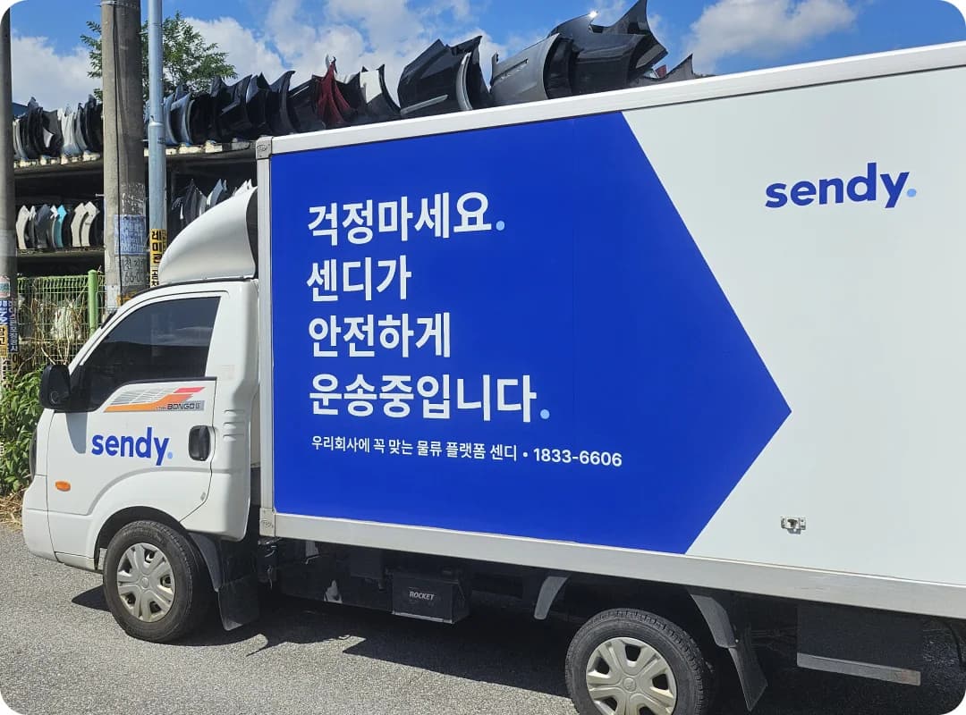 센디 로고와 안내 문구가 래핑된 운송 차량